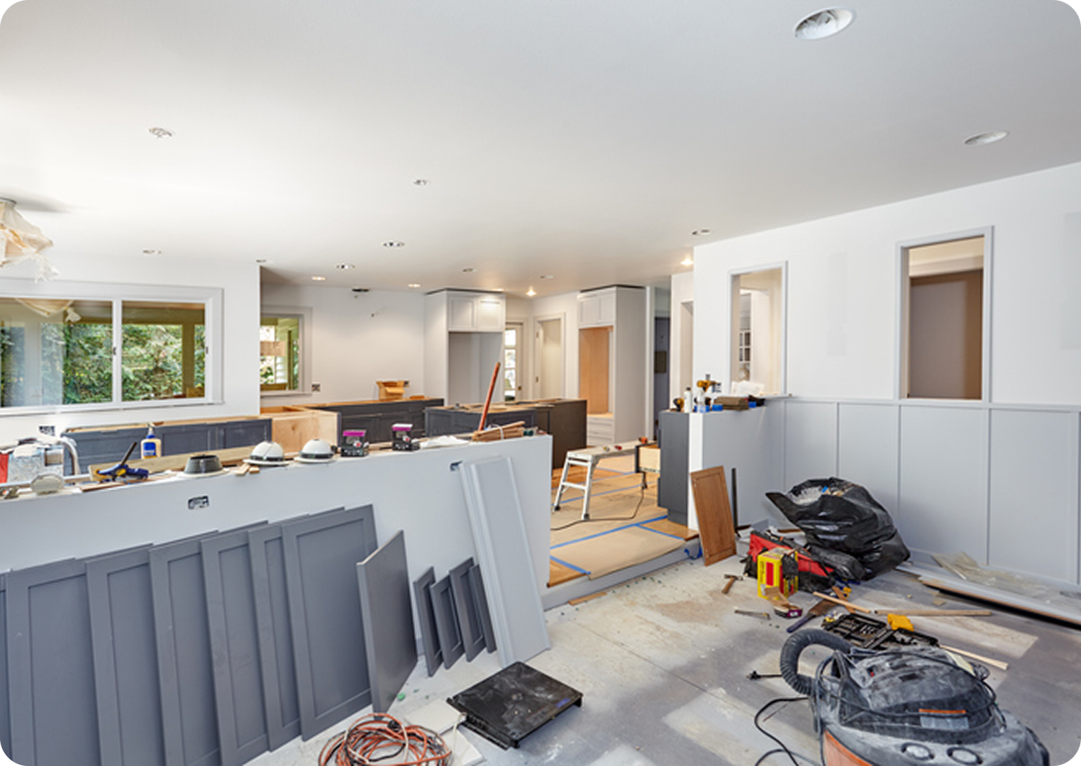 Kitchen under renovation with construction materials scattered.