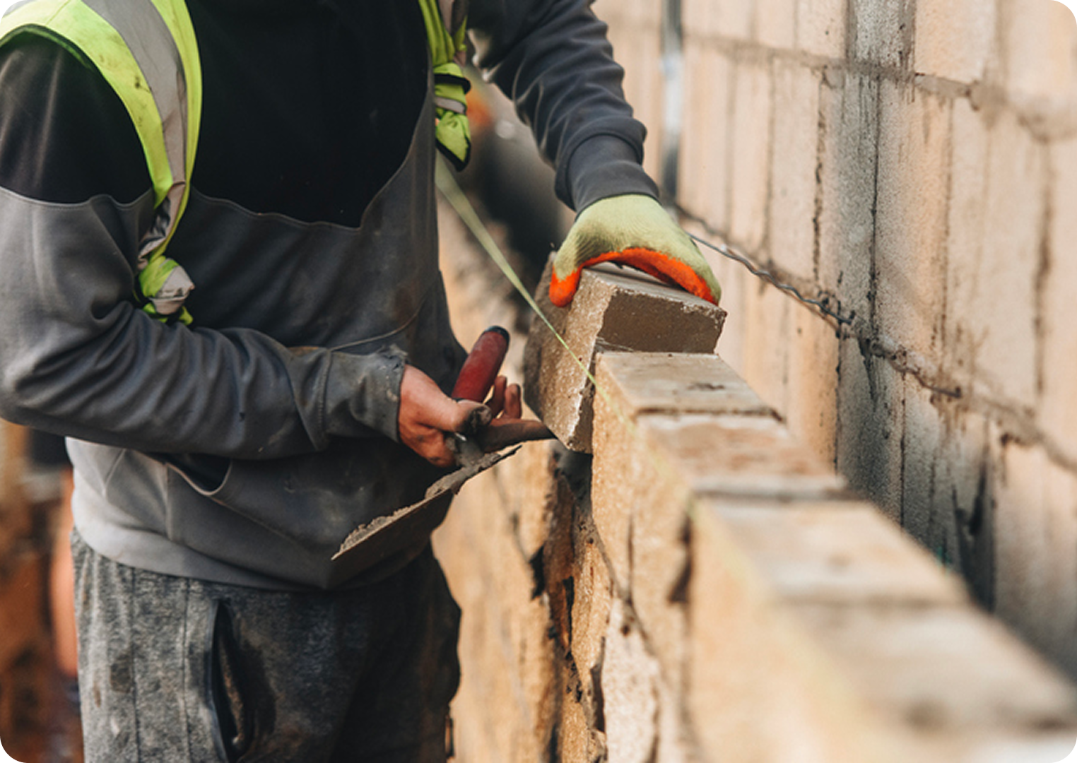 Builder laying bricks on a wall.