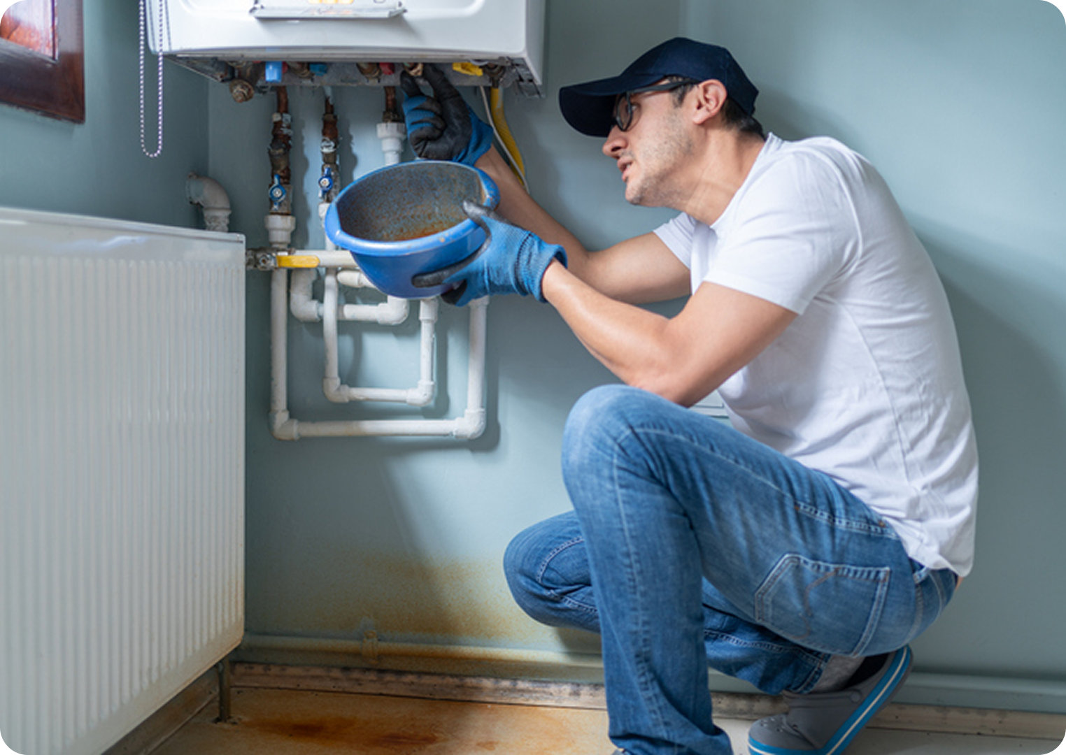 Man repairing a boiler with tools.
