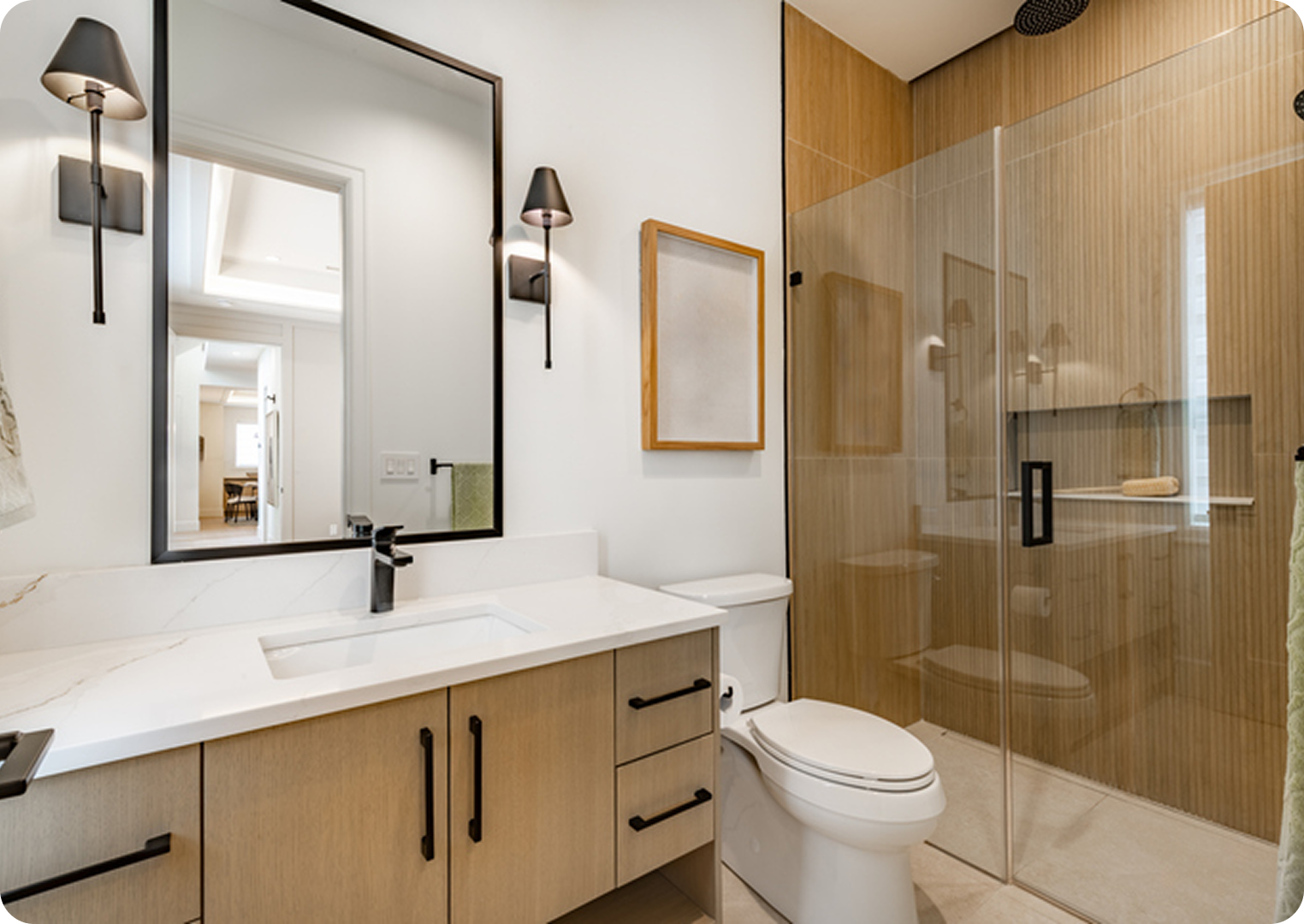 Modern bathroom with glass shower and wooden accents.