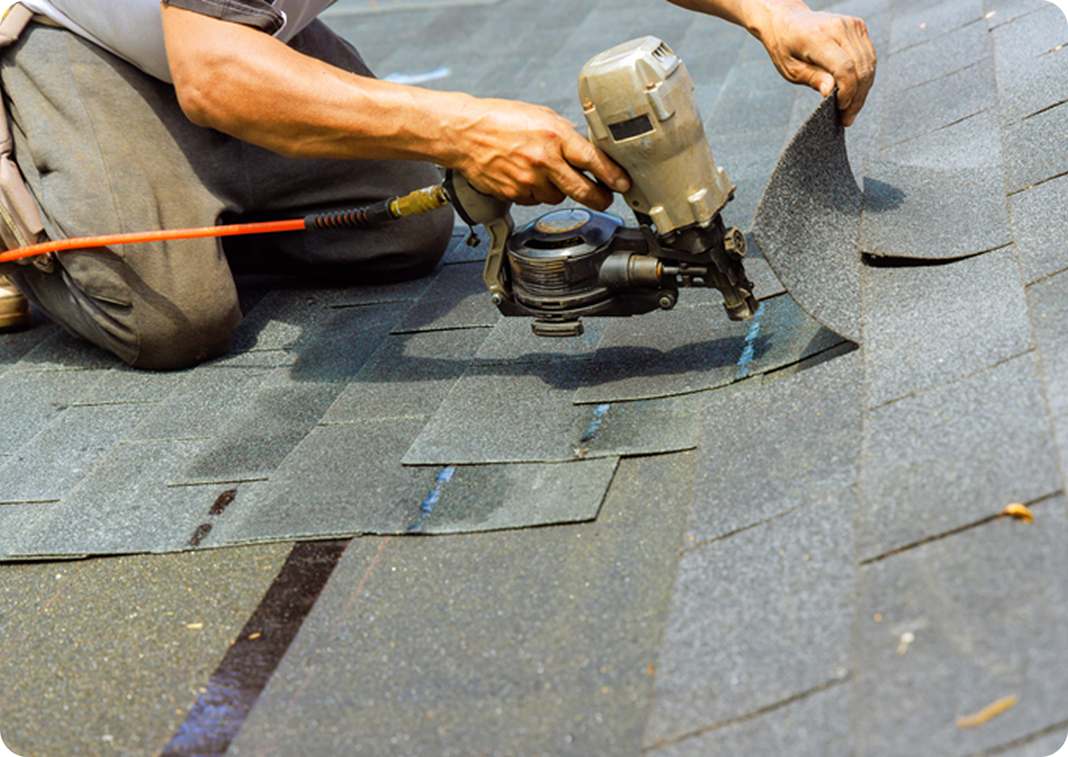 Worker installing asphalt roof shingles.