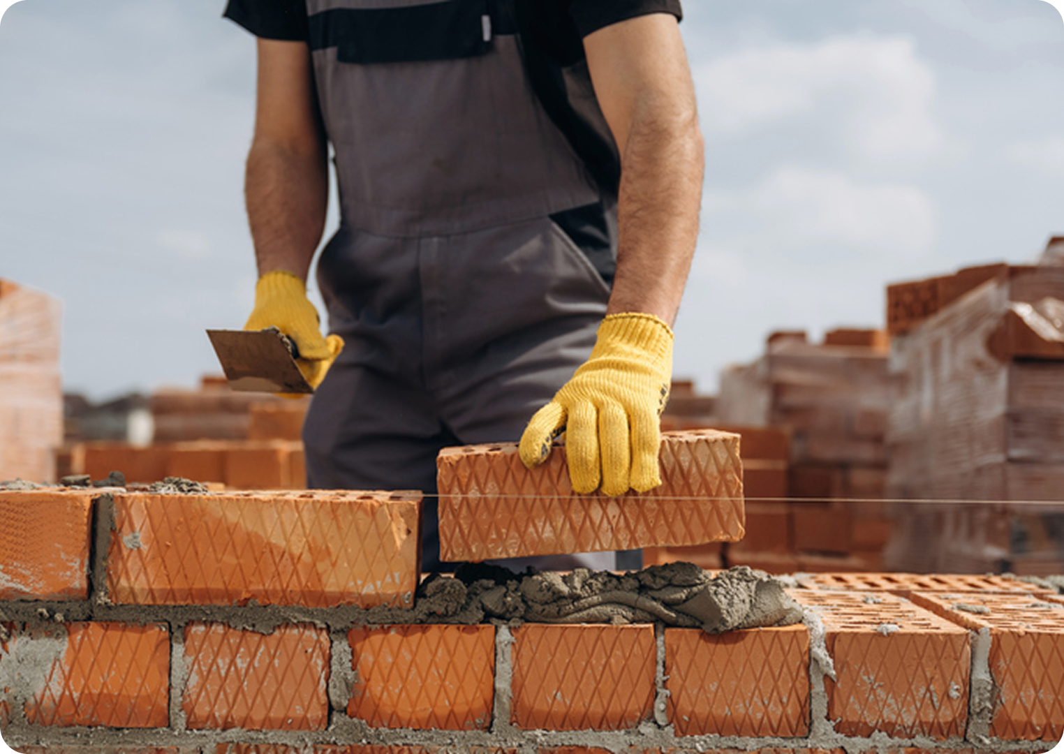 Bricklayer placing bricks on a wall.
