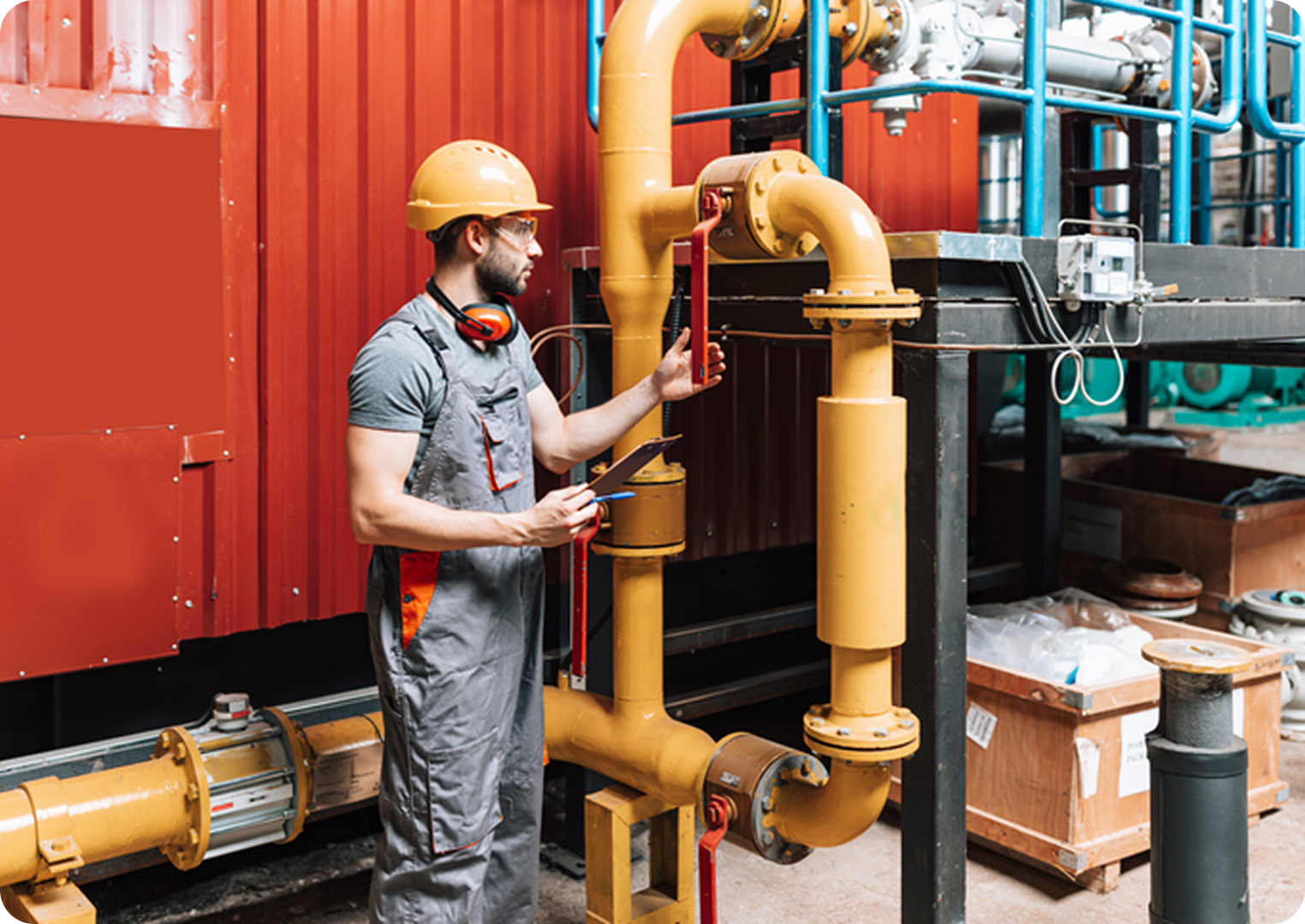 Worker inspecting industrial pipes at facility.