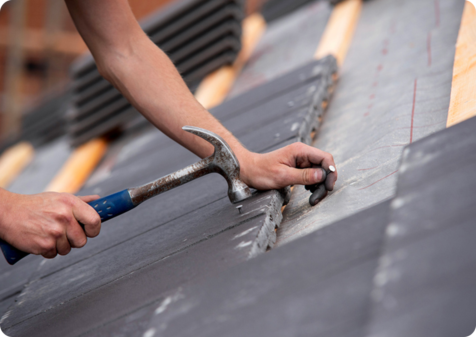 Person hammering nails on a roof.