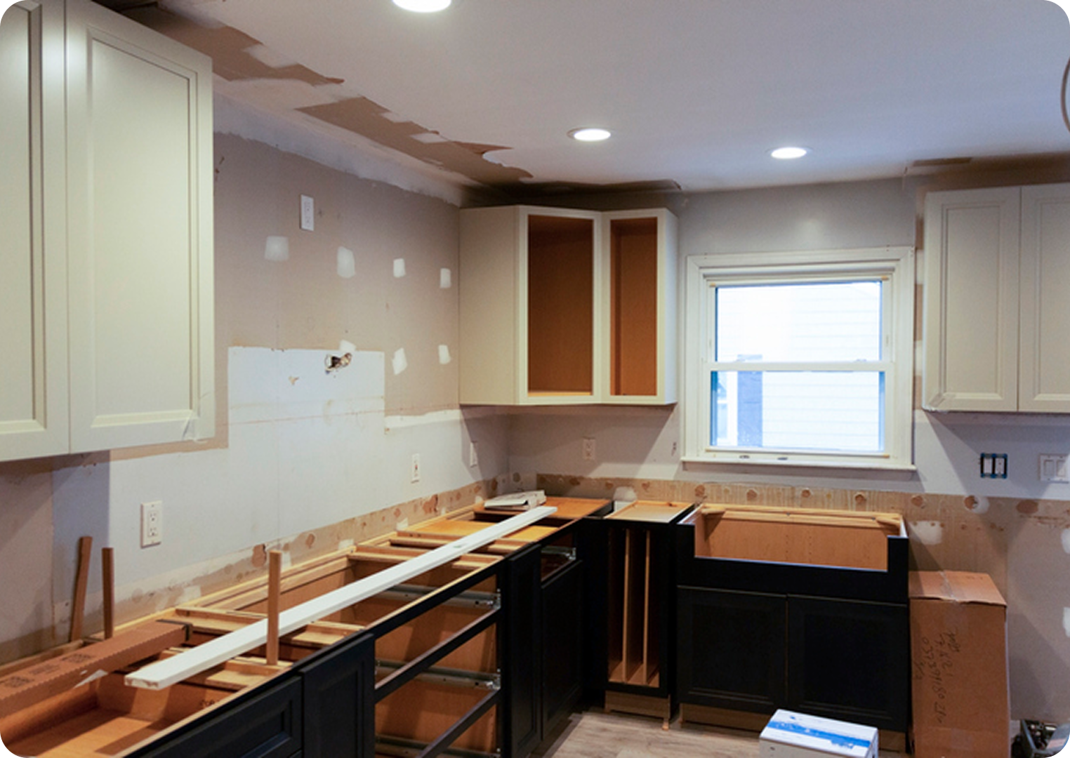 Kitchen under renovation with unassembled cabinets.