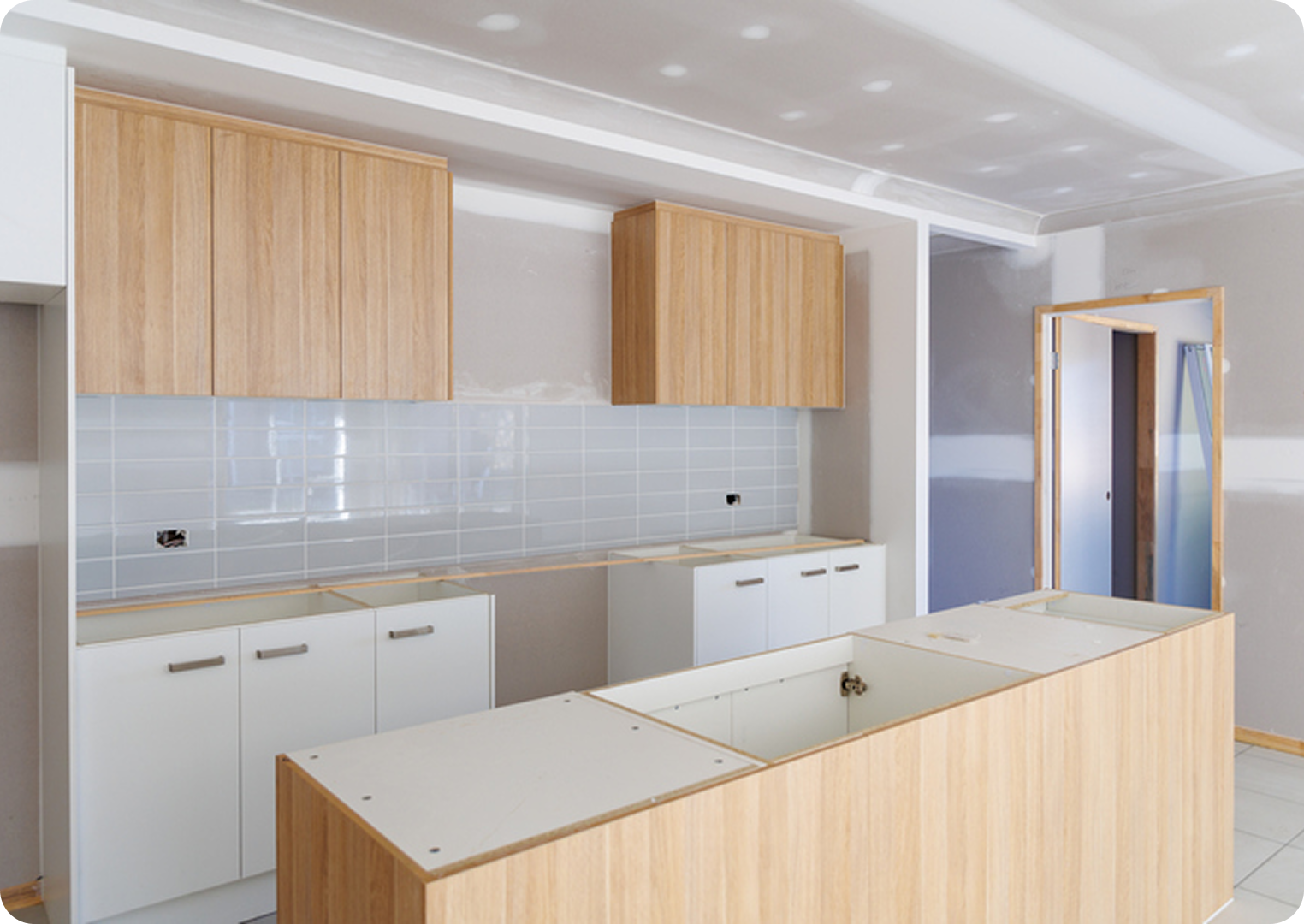Modern kitchen under construction with wooden cabinets.
