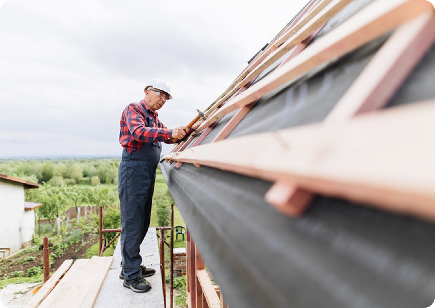 Man working on wooden roof structure.