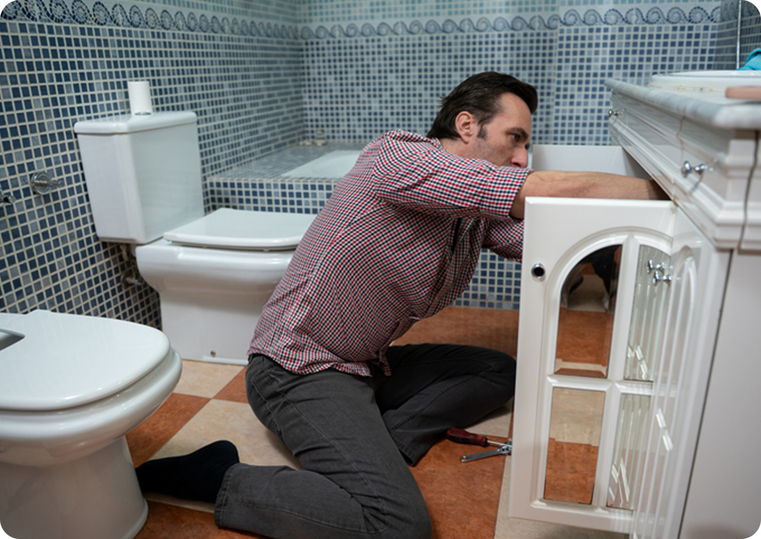 Man fixing bathroom sink cabinet.