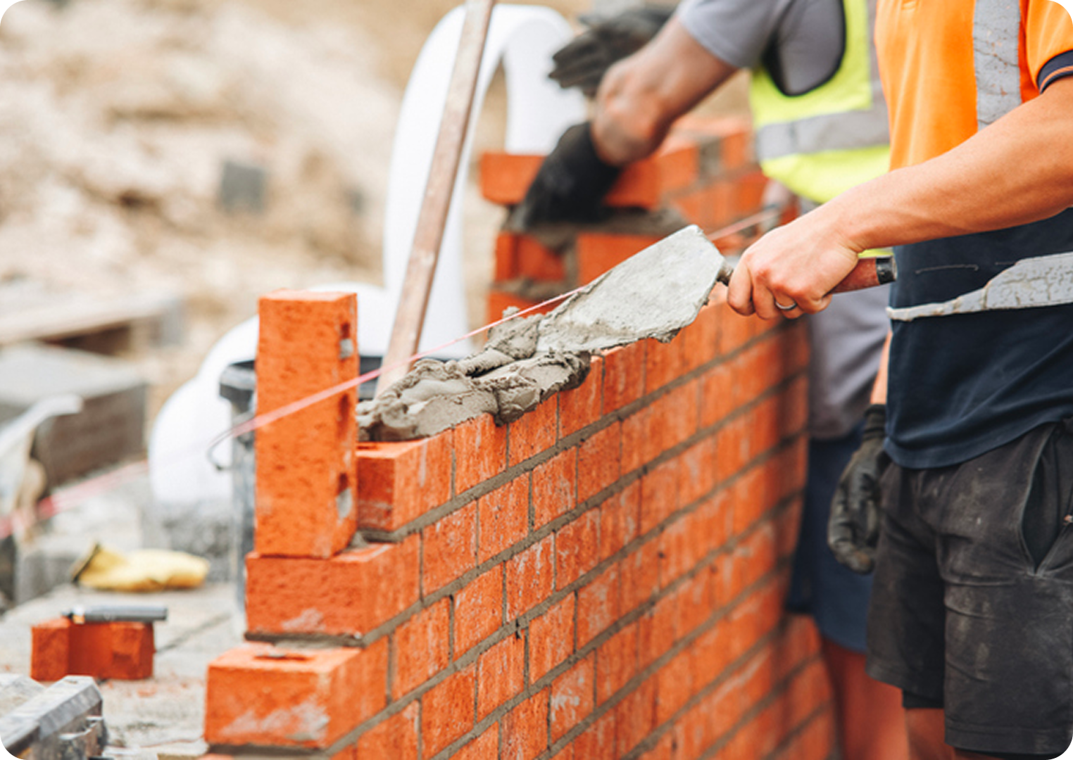 Bricklayer building a wall with mortar.