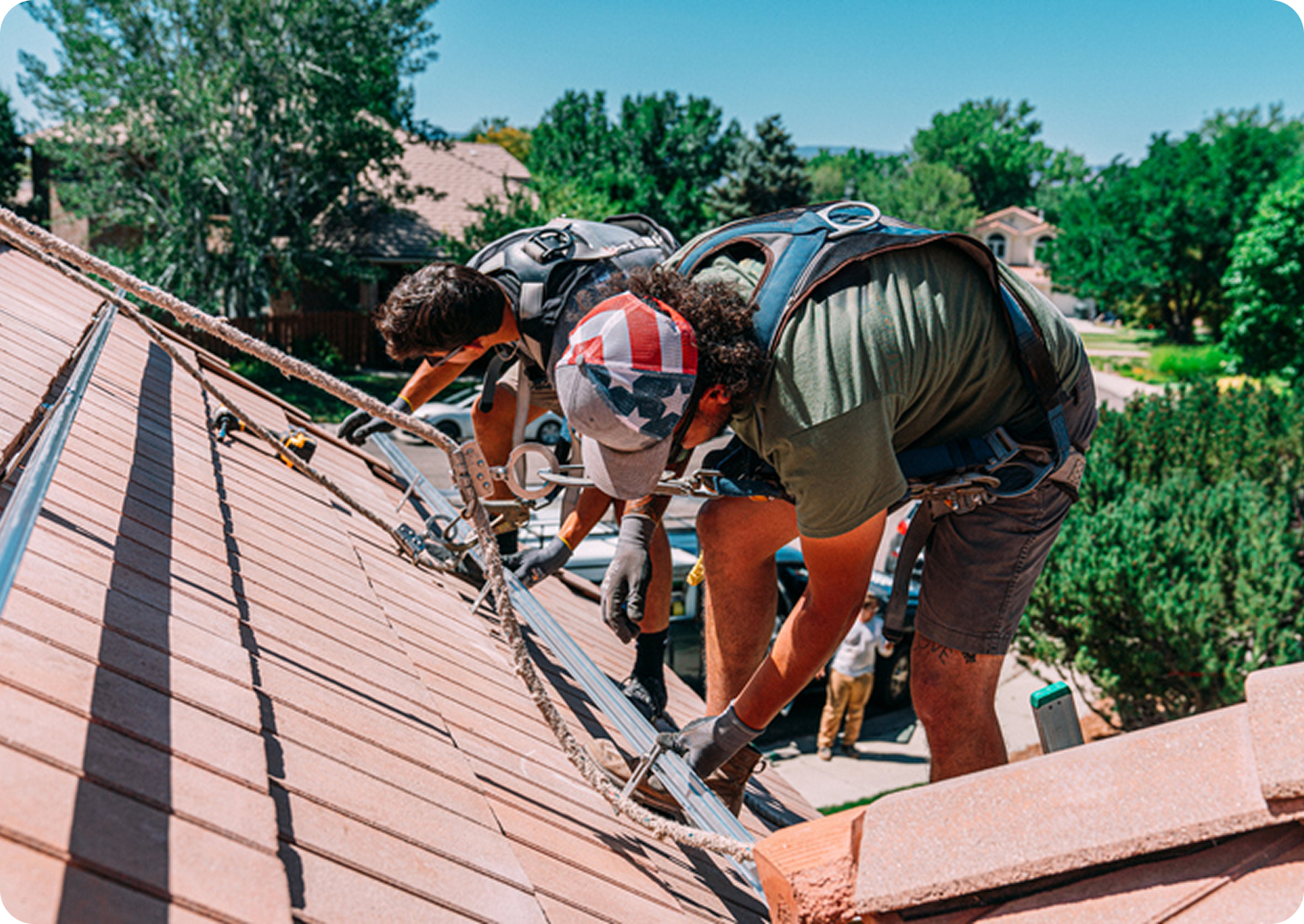 Workers installing solar panels on roof.
