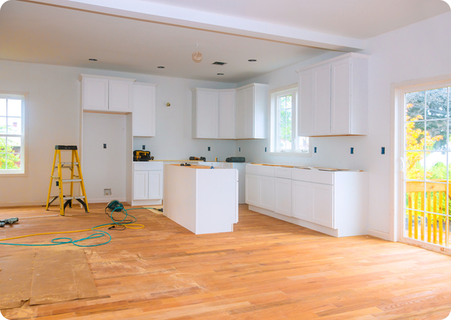 Kitchen under renovation with wooden flooring.