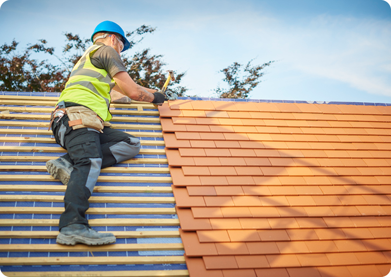 Roofer installing shingles on a roof.