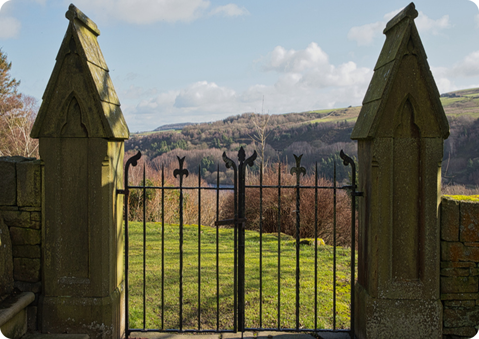 Stone gate with countryside view beyond.