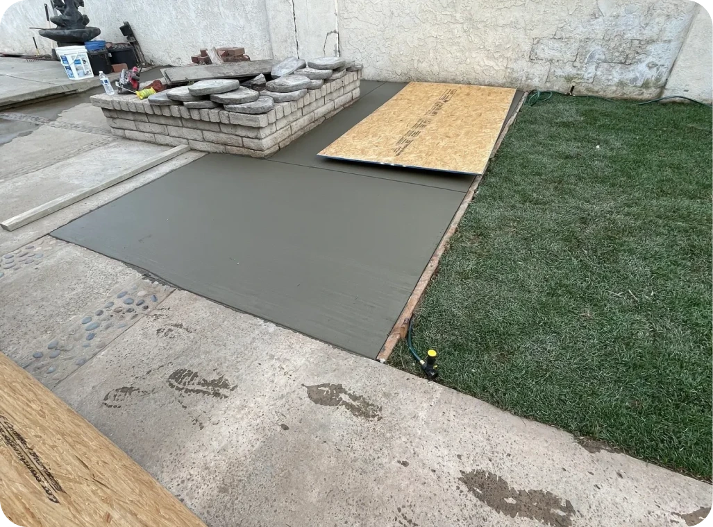 Fresh concrete slab next to grass area.