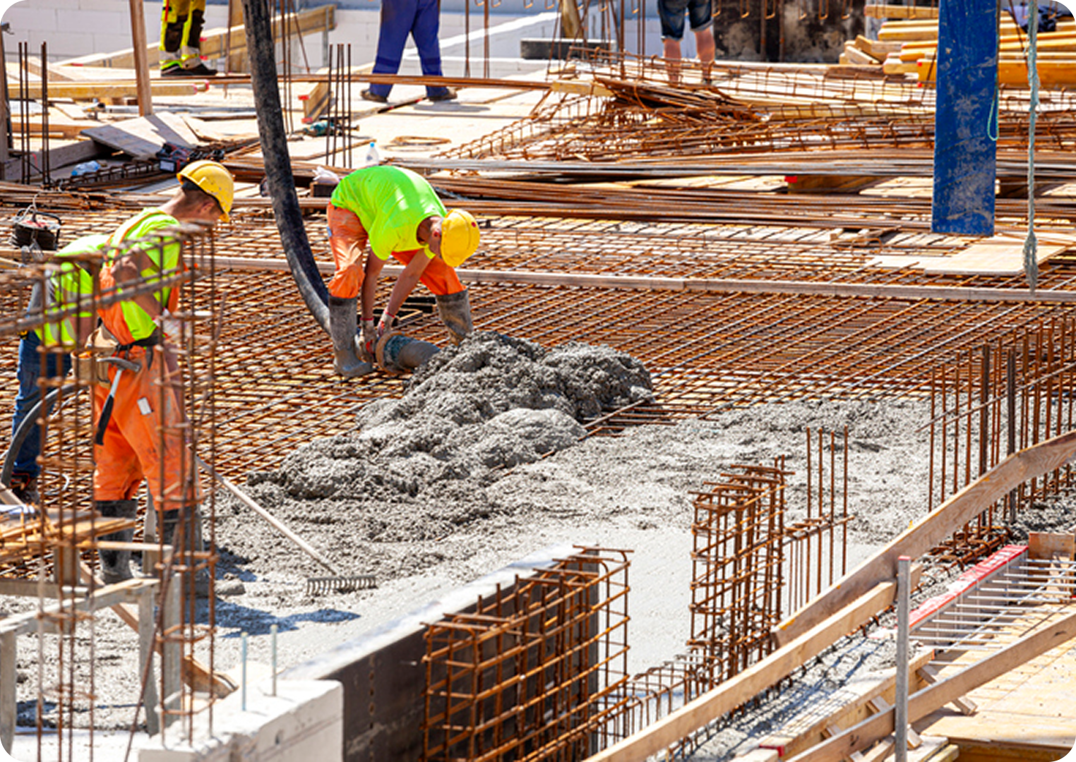 Construction workers pouring concrete on site.