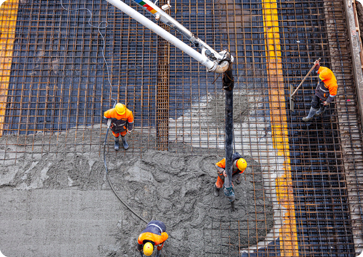 Construction workers pouring concrete on site.